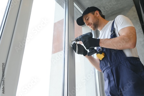 The foreman installs a window frame in the room