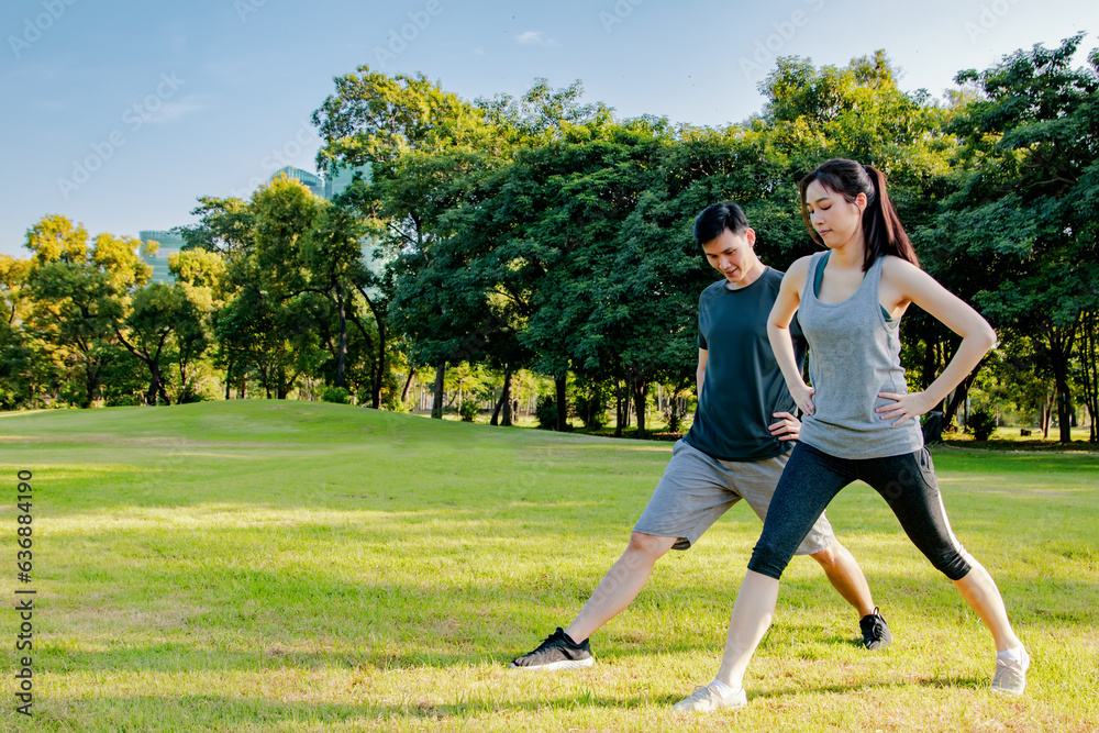 Healthy and attentive portrait asian couple doing sports warming up fitness stretching arms together in park lawn on sunny summer morning : Sports health care and recreational activities concept