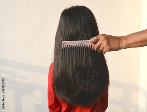 Back view of combing of hair of a girl