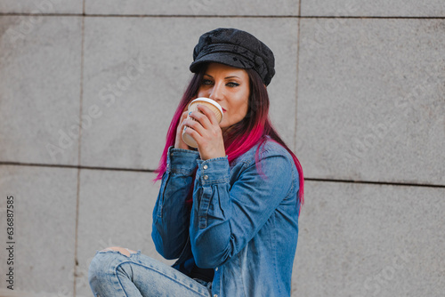 urban young woman with phone and coffee in the street