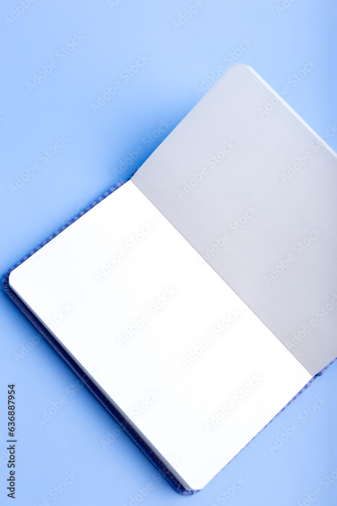 Opened white notepad mockup with place for text from above on blue background. Opened white notepad mockup with place for text from above on blue background.