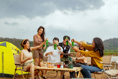 Meeting for fun vacation trips camping trips natural places : Happy group male and female friends singing songs and drinking beer having fun on vacation travel camping holiday trips natural fields. © ฺฺฺBoonterm