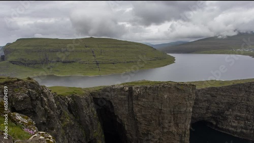 Faroe Islands landscape- Hike to the Traelanipa Slave Cliff near Leitisvatn Lake with steep drops into the ocean, Denmark. - Time lapse photo