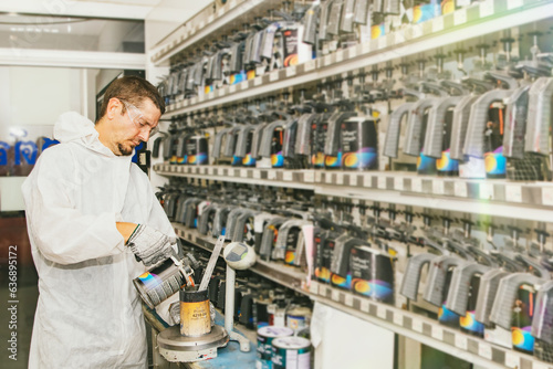 Foto Professional painters mix car paint formulas in the paint storage room and grade quality paints by mixing formulas with a standard 2K paint mix ratio according to customer requirements