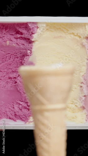 Wallpaper Mural Vertical video. A large container of assorted colorful ice cream appears in the frame behind the empty waffle cone. Torontodigital.ca