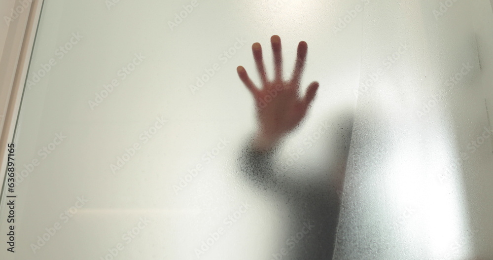 A man pastes a frosted coating on a glass door in a clinic to make the glass door opaque. Applying a matte coating to the glass. A man pastes a frosted coating on a glass door in a clinic to make the glass door opaque. Applying a matte coating to the glass.