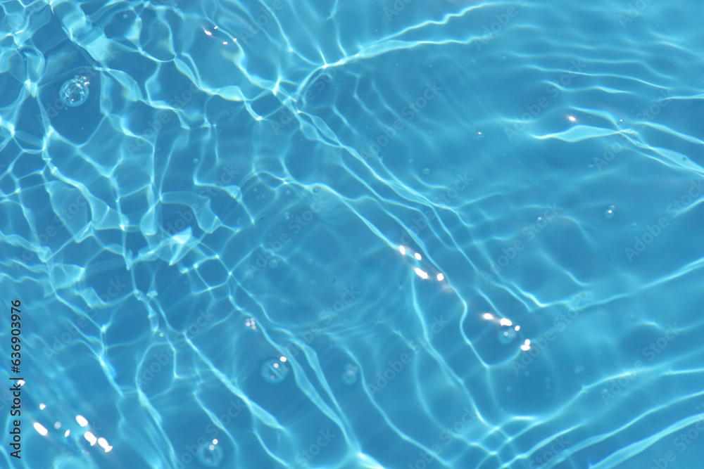 Blue water with ripples on the surface. Defocus blurred transparent blue colored clear calm water surface texture with splashes and bubbles. Water waves with shining pattern texture background. Blue water with ripples on the surface. Defocus blurred transparent blue colored clear calm water surface texture with splashes and bubbles. Water waves with shining pattern texture background.