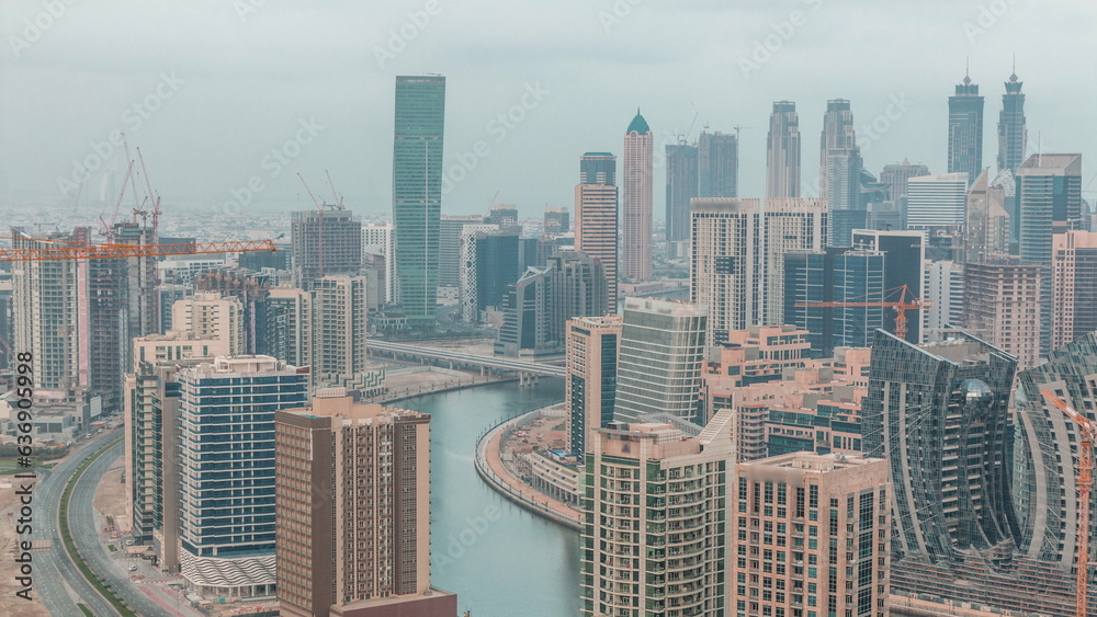 Skyline with modern architecture of Dubai business bay towers night to day timelapse. Aerial view