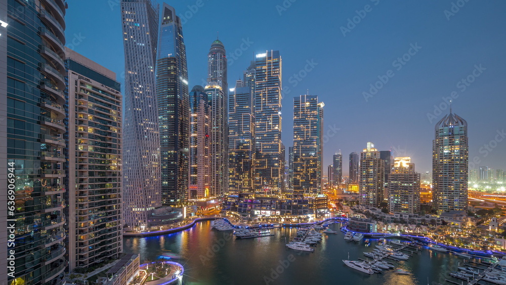 Dubai marina tallest skyscrapers and yachts in harbor aerial day to night timelapse.