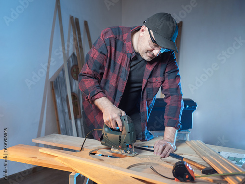 Man uses jigsaw. Guy works ...