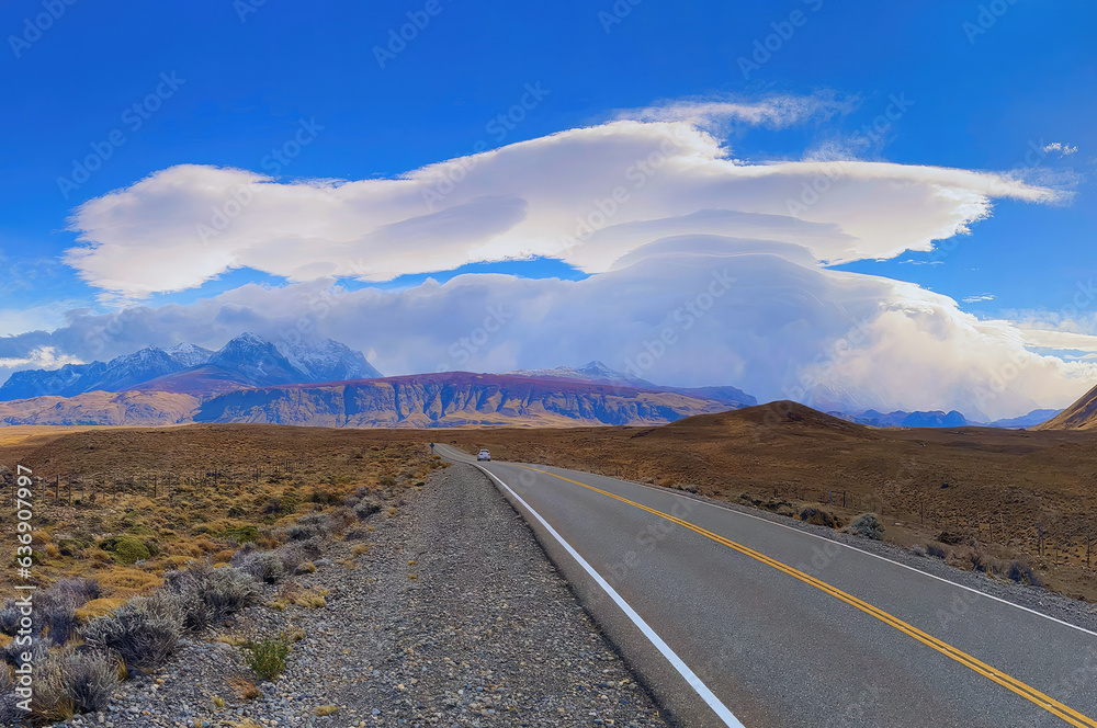 Beautiful landscape of mountain and clouds in blue sky at Patagonia in Argentina during autumn time. With the road that is the line of sight to the destination as foreground.