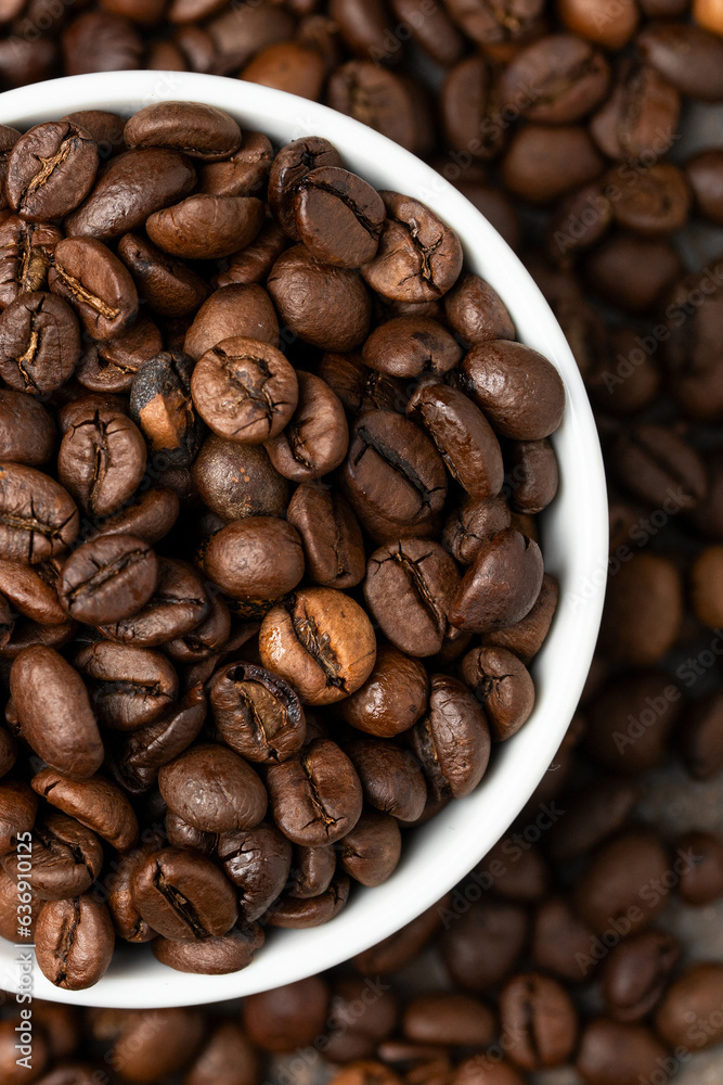 Naklejka premium Top view of white bowl with coffee beans . Coffee beans texture.Close up