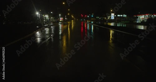 Driving along empty city street in the rain at night 2