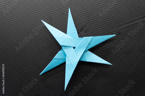Origami Ninja 3 point star on black background. diy. paper craft. 