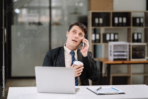 Smiling businessman freelancer working from home remotely.He is talking on the phone.