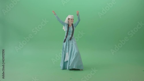 Funny dance by beautiful georgian woman in blue dress isolated on green screen 4K Video Footage photo