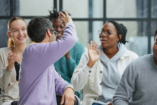 Excited motivated multi-ethnic team people give high five in office