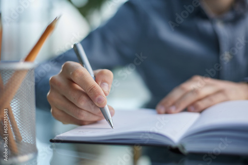 pensive male entrepreneur coming up with idea while taking notes