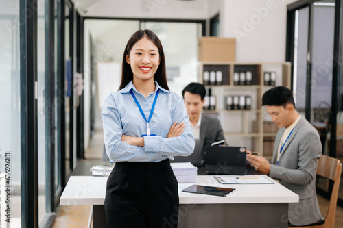 Young attractive Asian female office worker business suits smiling at camera in office .