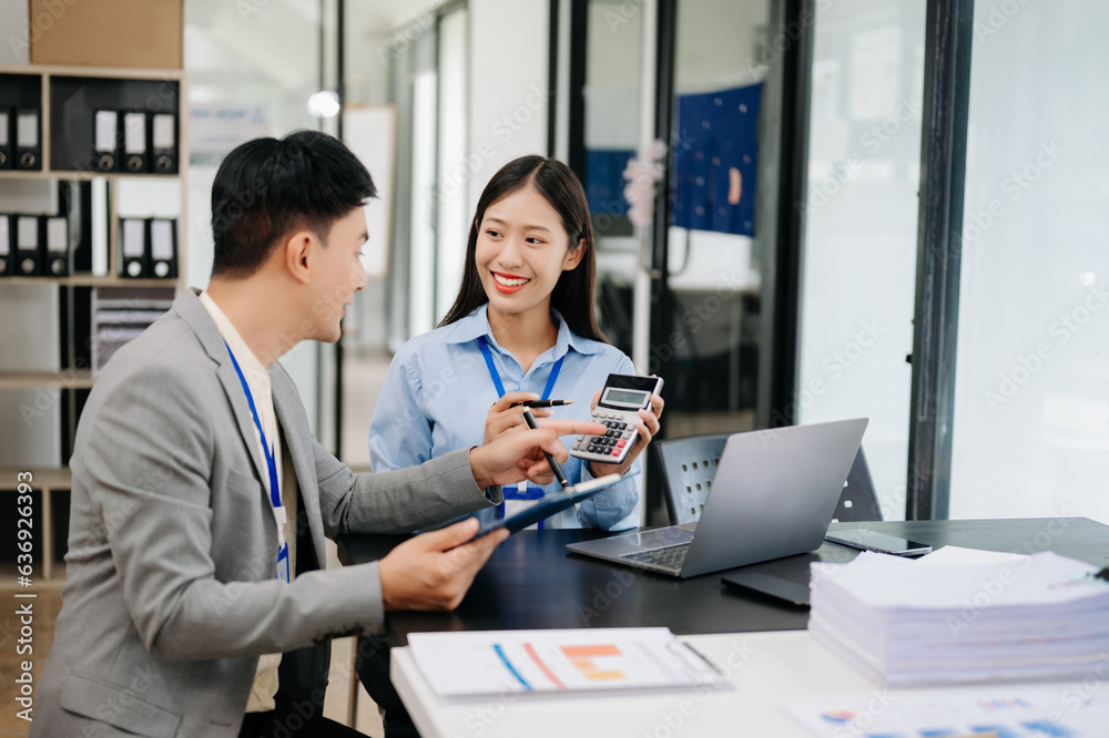 Two business workers talking on the smartphone, calculator and using laptop at the modern office.. Two business workers talking on the smartphone, calculator and using laptop at the modern office..