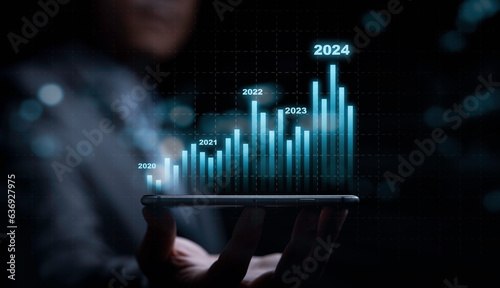 Businessman holding smartphone with technical stock market graph chart for trader analysis investment data to get increasing profit and high dividend , Financial banking and economic concept.