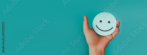 Fototapeta Naklejka Na Ścianę i Meble -  Hand holding paper cut happy smile face, Positive thinking, Mental health assessment , World mental health day concept