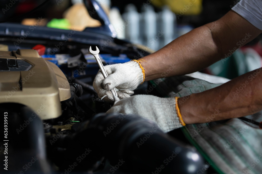 closeup mechanic worker hands checking and fixing a car in garage closeup mechanic worker hands checking and fixing a car in garage