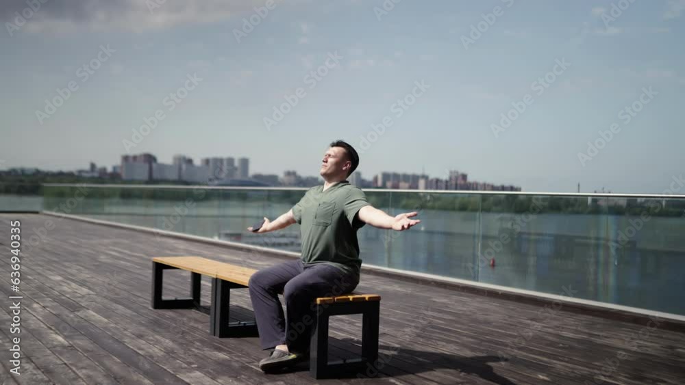 A man meditates in the bright sun near his apartment complex. A man meditates in the bright sun near his apartment complex.