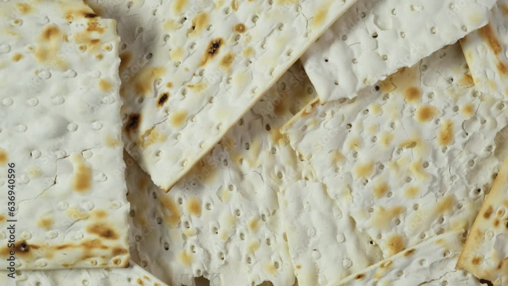 Matzah or Matzo kosher food for Passover, made from flour and water. Unleavened flatbread. Jewish cuisine. 4K Video, Rotating.