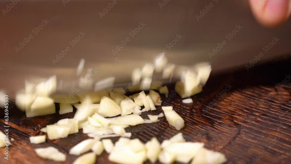 male hands cut garlic on a wooden board. close-up
male hands cut garlic on a wooden board. close-up