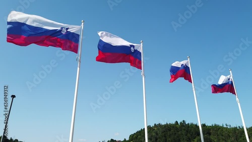 Row of waving National flags of Slovenia against a blue sky