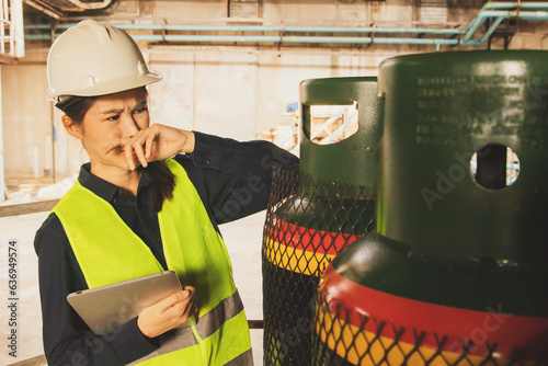 Billede på lærred Safety officer female inspector working in factory safety checking valves (NH3) ammonia chemical tanks having respiratory symptoms, burning nose pungent hazards from chemical spills
