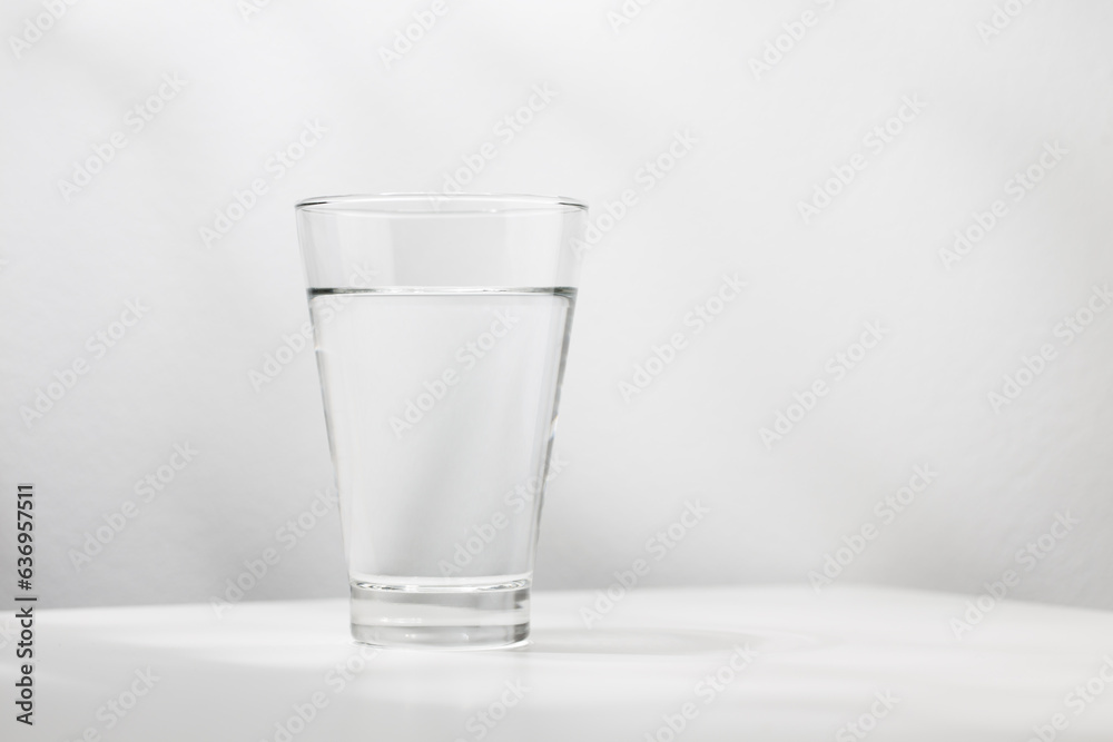 Pure water in the glass is on the white wooden table. Pure water in the glass is on the white wooden table.