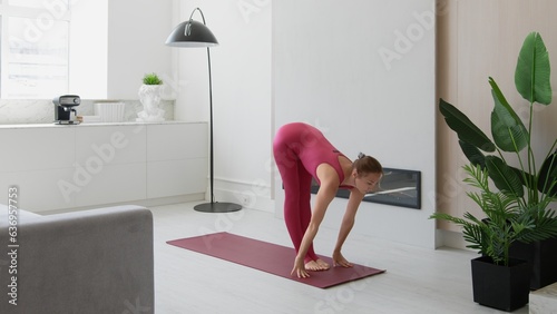 Beautiful athletic woman does aerobic exercises, workout, yoga, stretching. Morning apartment healthy female staying mindful