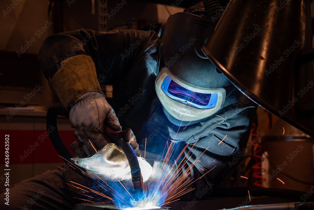 welder is welding metal part in car factory welder is welding metal part in car factory