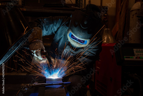 welder is welding metal part in car factory