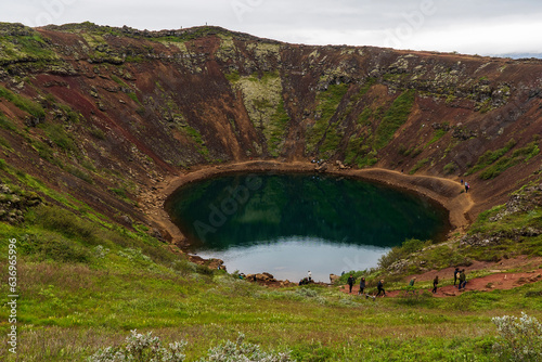 Kerid, volcanic crate lake in the Grimsnes area of South Iceland. Hiking along the lake is popular.. Area shows reddened iron deposits. Lake is vividly colored due to minerals from the rocks. photo