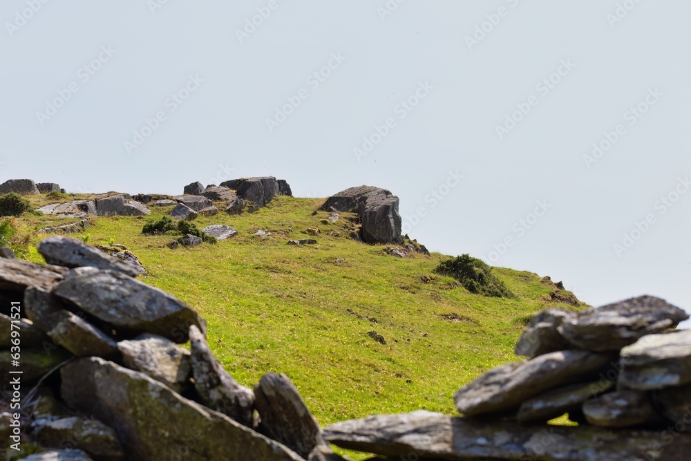 landscape with rocks green grass on top of mountain