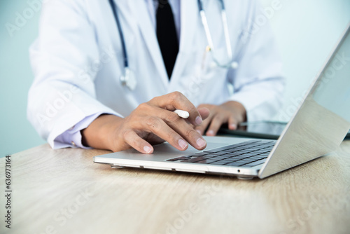 In the hospital, doctor using laptop for medical professionals to access patient information, manage medical records, and stay up-to-date with medical research and developments. Physician input data.