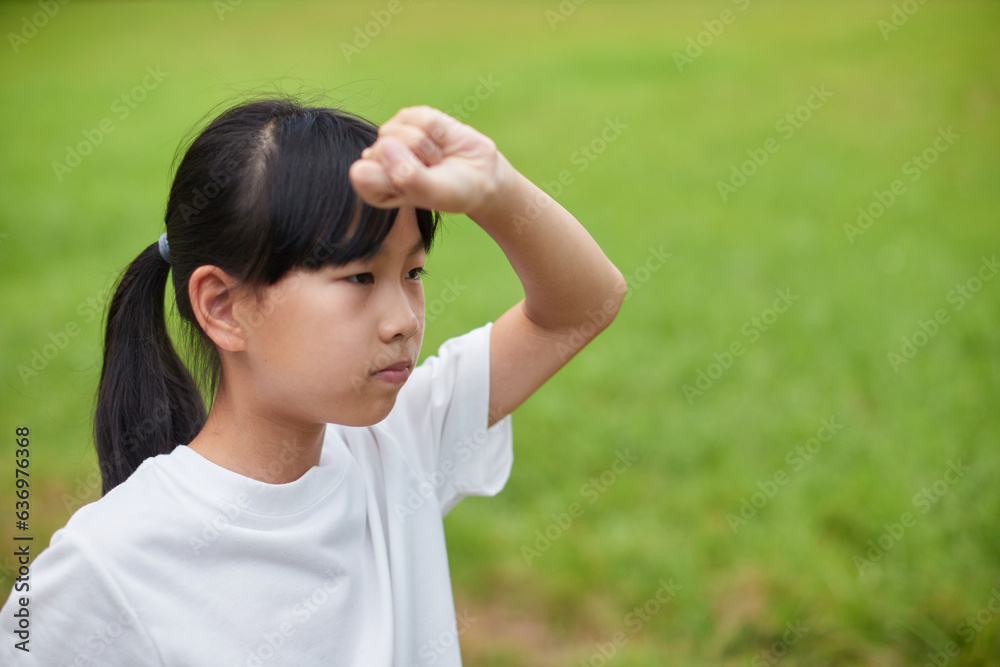 真夏の公園で空手を練習している小学生の女の子の様子 真夏の公園で空手を練習している小学生の女の子の様子
