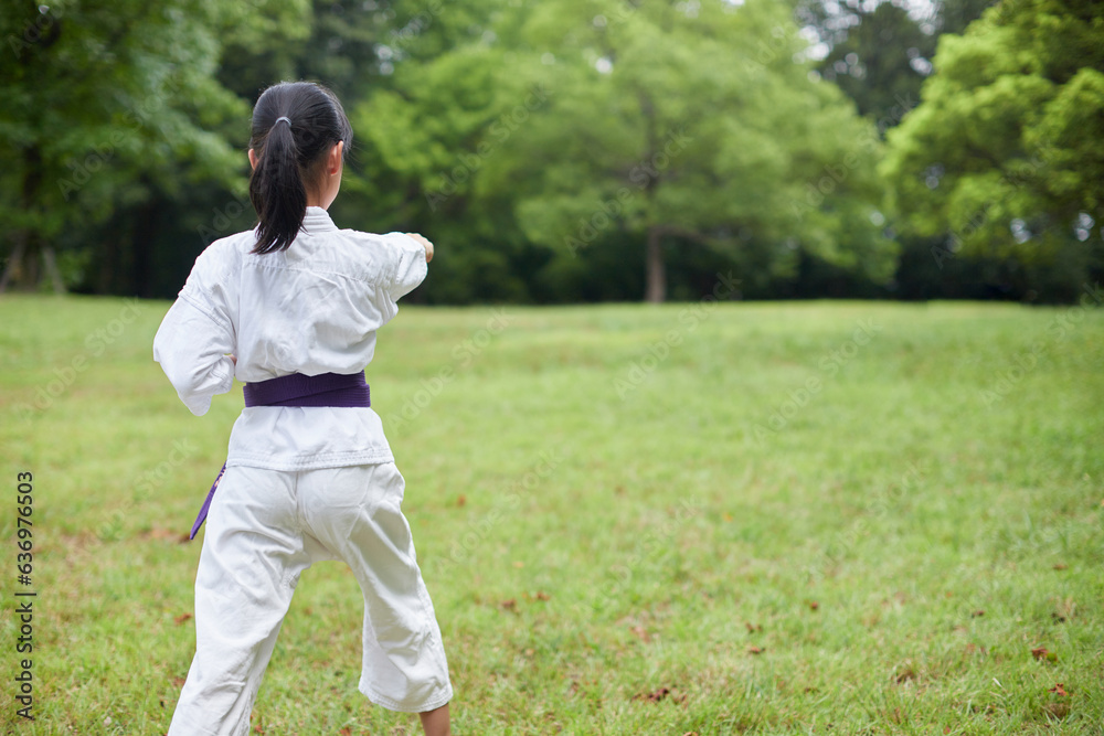 真夏の公園で空手を練習している小学生の女の子の様子