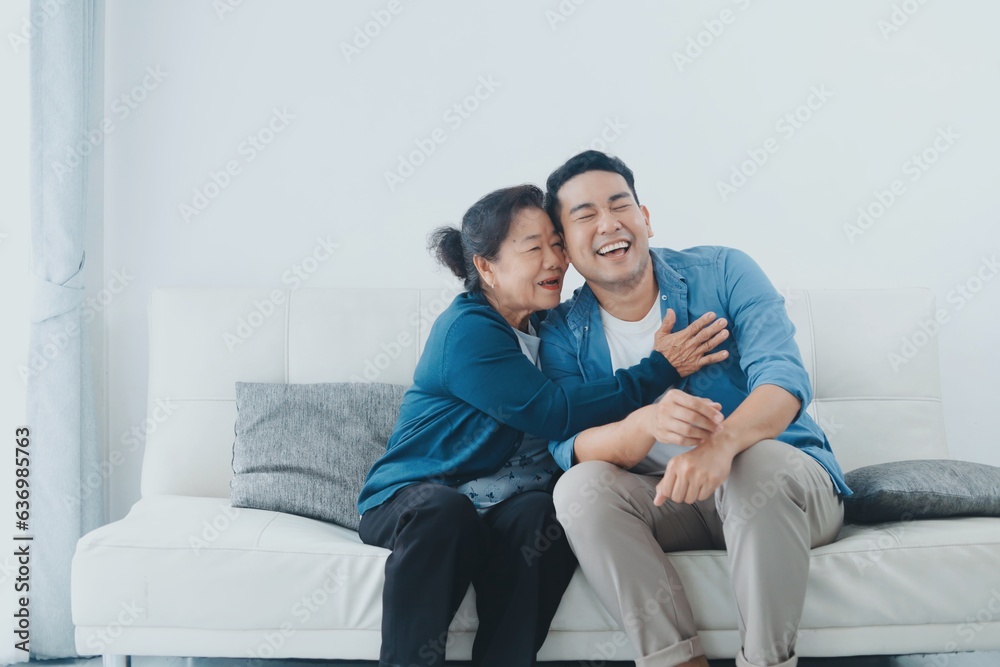 Happy Asian senior with smiling Asian man sitting sofa in living room ,Portrait Happy mother and son in living room ,Happiness family concept.