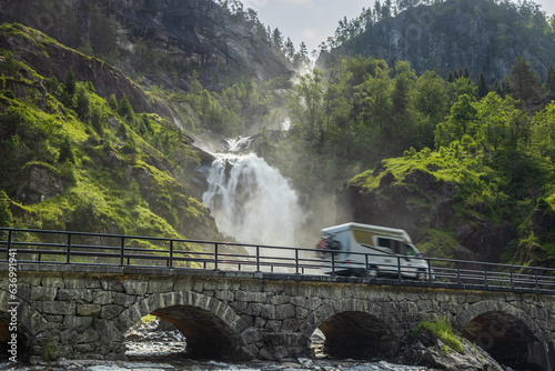 Holiday trip in motorhome, Caravan car Vacation. RV traveling on the road Latefossen Waterfall Odda Norway. Latefoss is a powerful, twin waterfall. photo