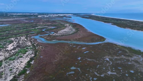 Sunset over salt pans and marsh in Tavira in the district of Faro. Aerial view from a drone. Marshes and salt flats of the Ria Formosa Natural Park. Atlantic Ocean. Algarve. Portugal. Europe