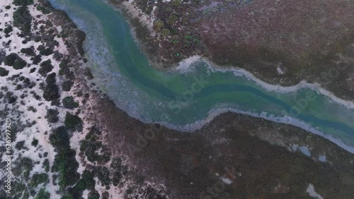Sunset over salt pans and marsh in Tavira in the district of Faro. Aerial view from a drone. Marshes and salt flats of the Ria Formosa Natural Park. Atlantic Ocean. Algarve. Portugal. Europe