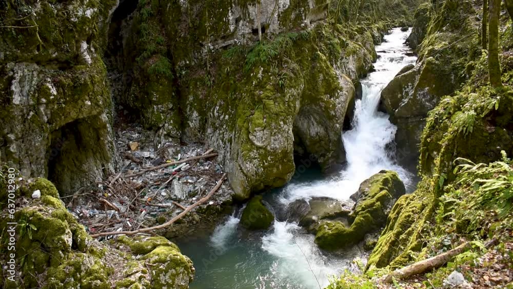 Waterfall and waste on mountain stream, Svrakava stream in rural area near Banja Luka and plastic pollution Waterfall and waste on mountain stream, Svrakava stream in rural area near Banja Luka and plastic pollution