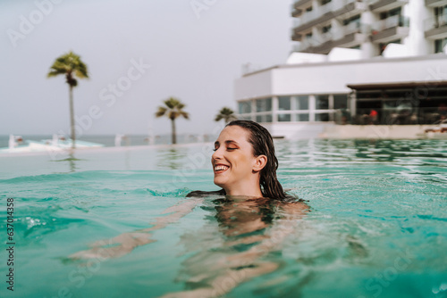 Chica joven nadando en piscina de un hotel 
