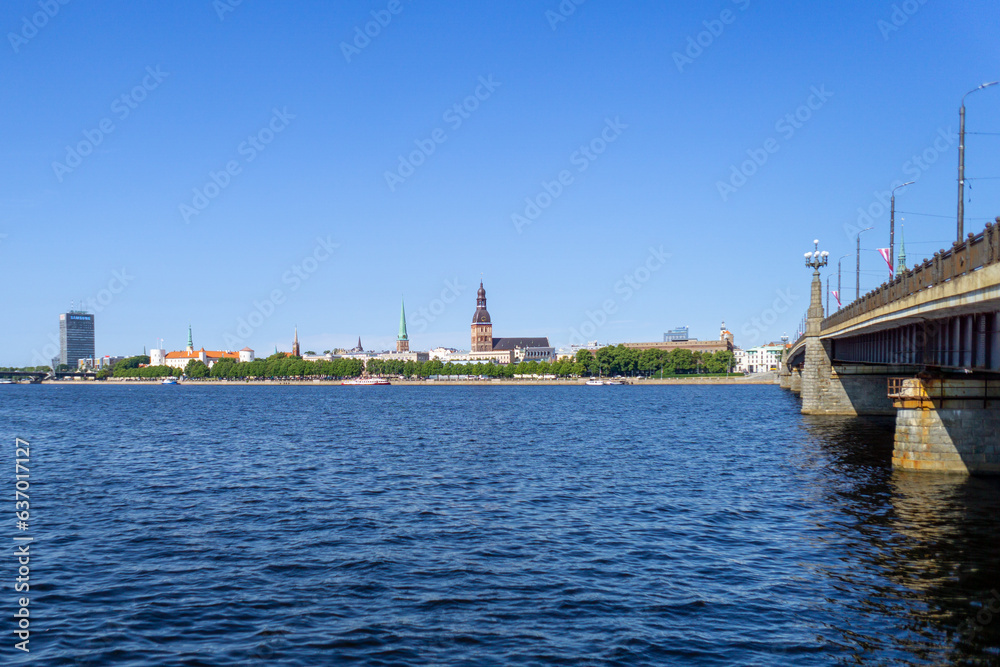 View of the Riga skyline from the other side of the Daugava river, on a sunny day.