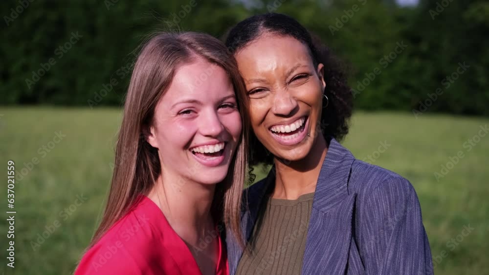 Two young women laughing outdoors during a fun afternoon in the park. Concept: lifestyle, friendship, smile Two young women laughing outdoors during a fun afternoon in the park. Concept: lifestyle, friendship, smile