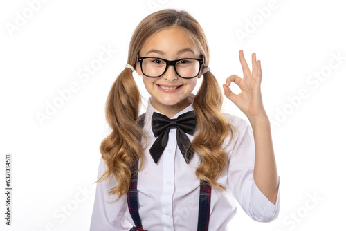 Cheerful schoolgirl shows ok gesture with fingers. Girl 9 years old